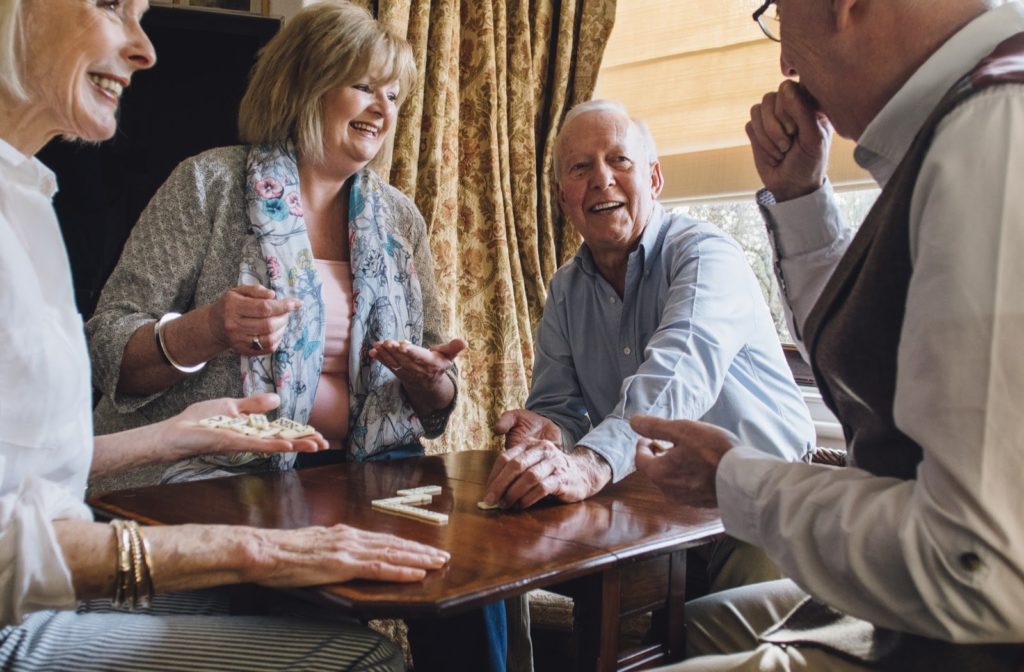 A group of older adults spending time together playing dominoes