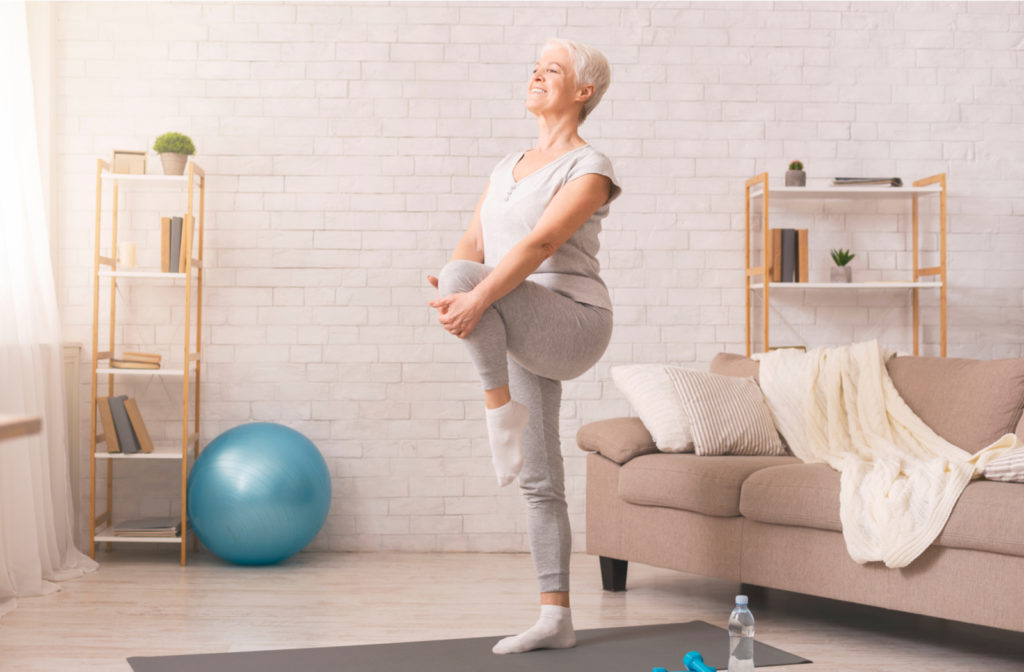 Senior women performing balance exercises in her living room